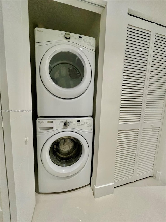 clothes washing area featuring stacked washer and clothes dryer