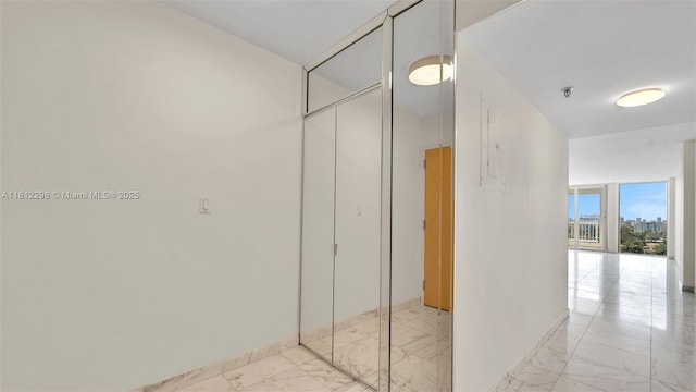 hall with baseboards and marble finish floor