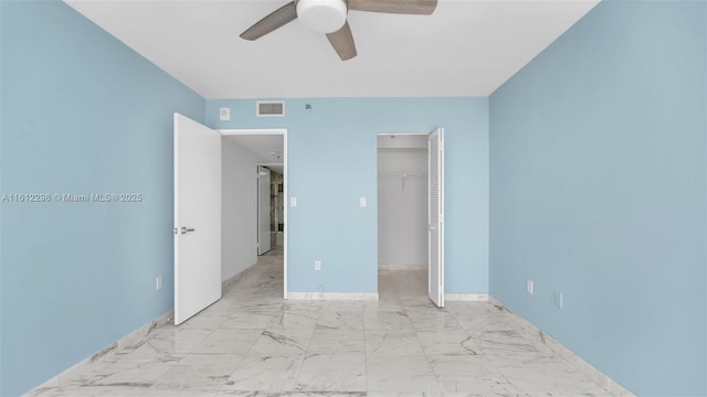 unfurnished bedroom with a closet, marble finish floor, visible vents, a ceiling fan, and baseboards