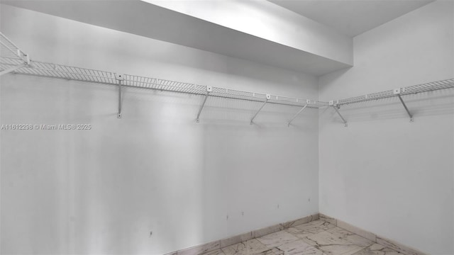 spacious closet featuring marble finish floor