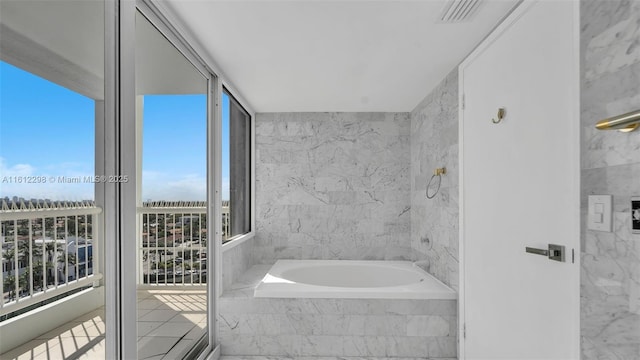bathroom featuring tiled bath and visible vents