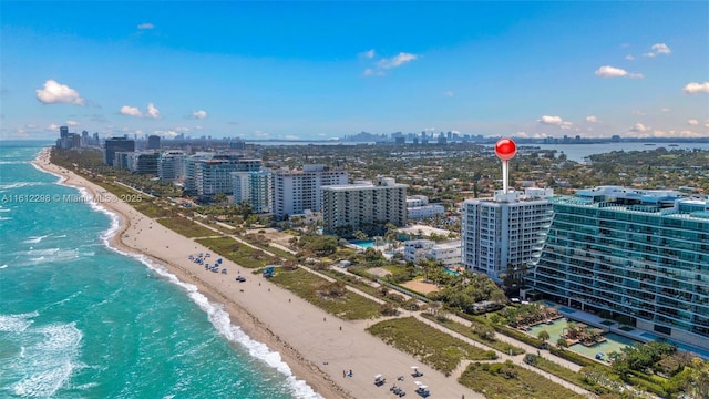 drone / aerial view featuring a beach view, a city view, and a water view