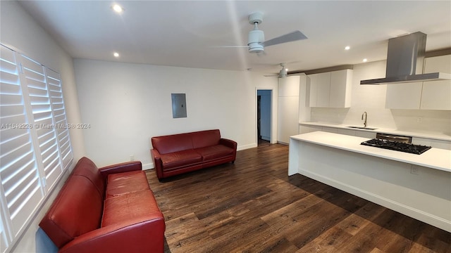 living room featuring ceiling fan, sink, dark hardwood / wood-style flooring, and electric panel