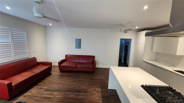 living room with dark hardwood / wood-style flooring, electric panel, and ceiling fan