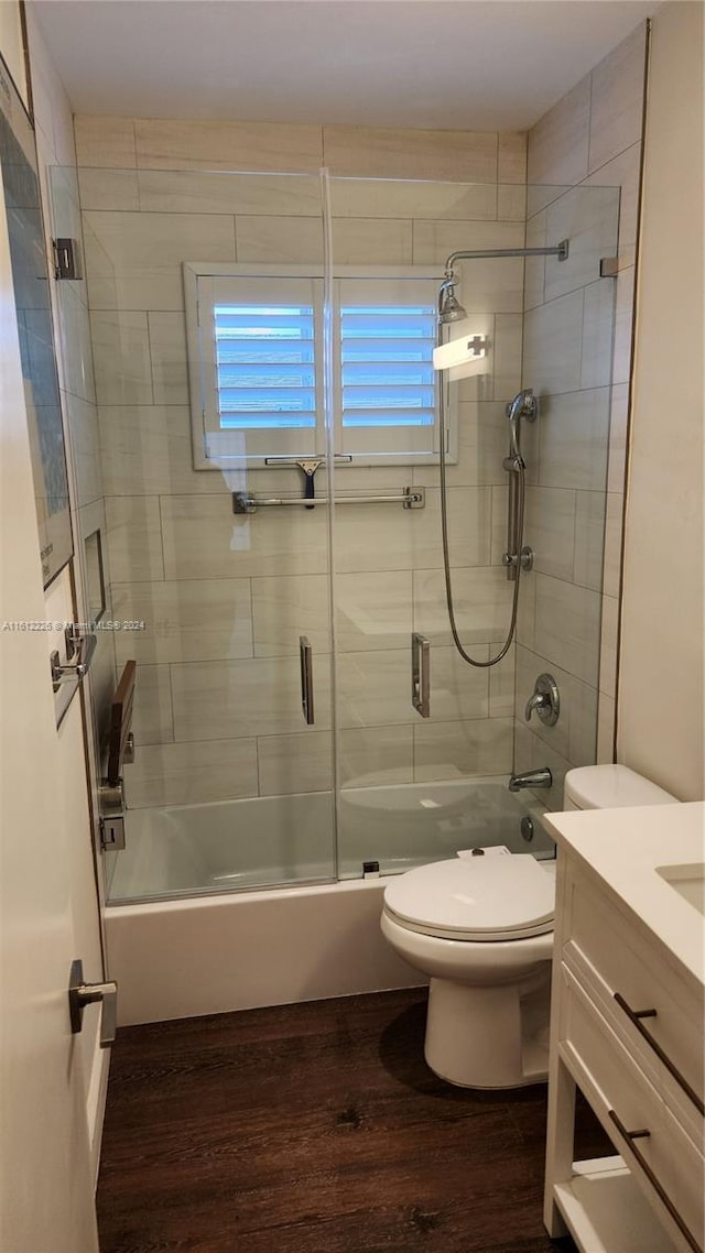 full bathroom with vanity, shower / bath combination with glass door, toilet, and wood-type flooring