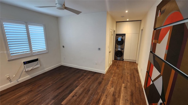 interior space with ceiling fan, a wall mounted AC, wood-type flooring, and stacked washing maching and dryer