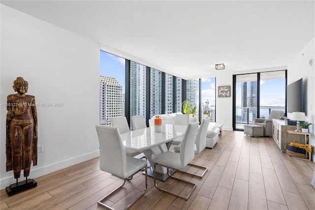 dining area featuring a wall of windows and light hardwood / wood-style flooring