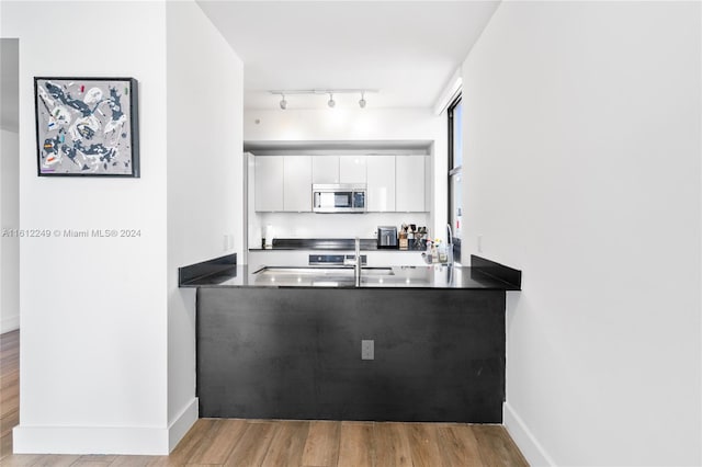 kitchen featuring light wood-type flooring and white cabinets