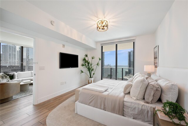 1010 Brickell Ave Unit 2201, Miami, FL 33131 - bedroom featuring multiple windows, access to outside, wood finished floors, a wall of windows, and baseboards