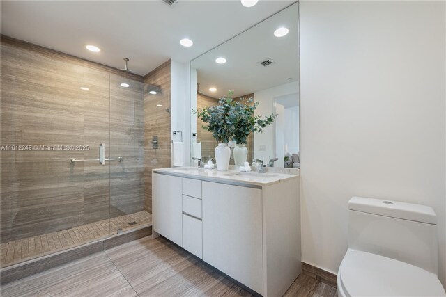 1010 Brickell Ave Unit 2201, Miami, FL 33131 - bathroom with toilet, a stall shower, recessed lighting, wood finished floors, and double vanity