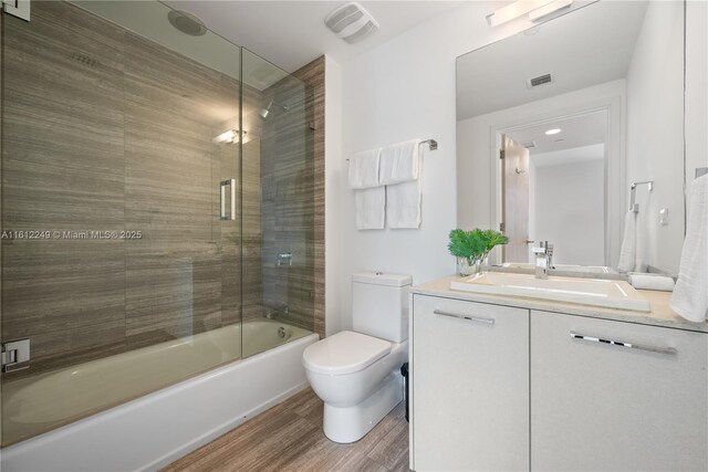 1010 Brickell Ave Unit 2201, Miami, FL 33131 - bathroom featuring wood finished floors, toilet, bath / shower combo with glass door, and vanity