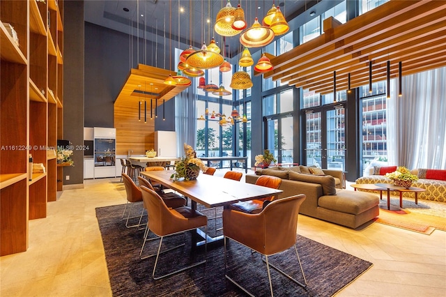 dining space featuring a towering ceiling and plenty of natural light