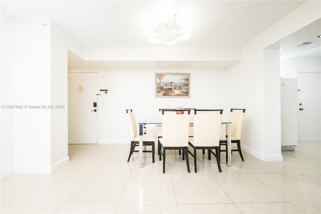 dining space featuring a chandelier and light tile floors