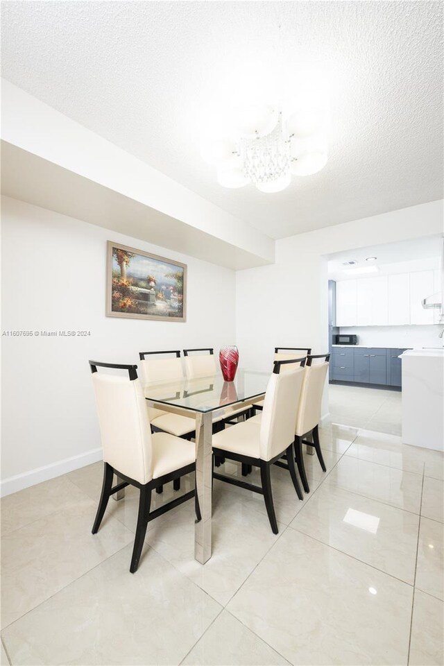 dining space featuring a textured ceiling and light tile flooring