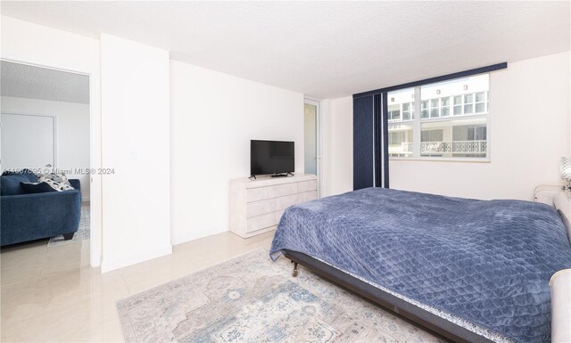 tiled bedroom featuring a textured ceiling