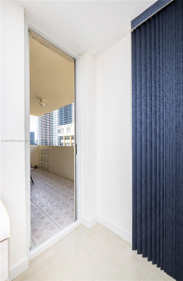 tiled empty room with a textured ceiling