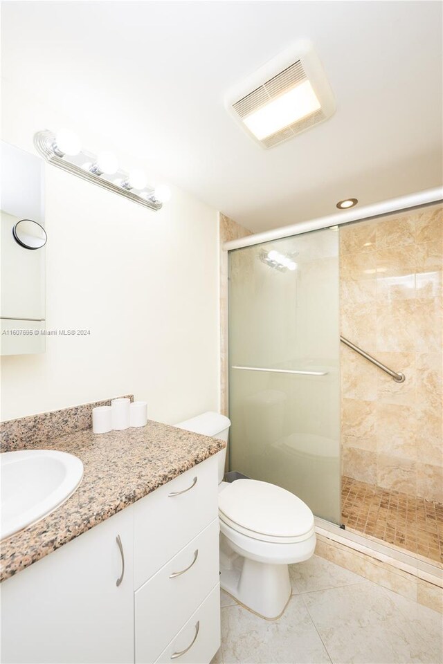 bathroom with walk in shower, tile flooring, toilet, and oversized vanity