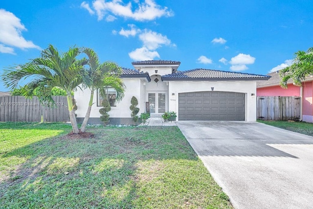 mediterranean / spanish house featuring a garage and a front lawn