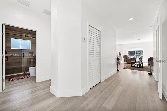 hallway with light hardwood / wood-style floors