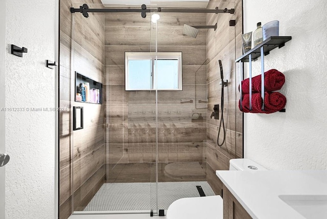 bathroom featuring vanity, toilet, and a shower with shower door