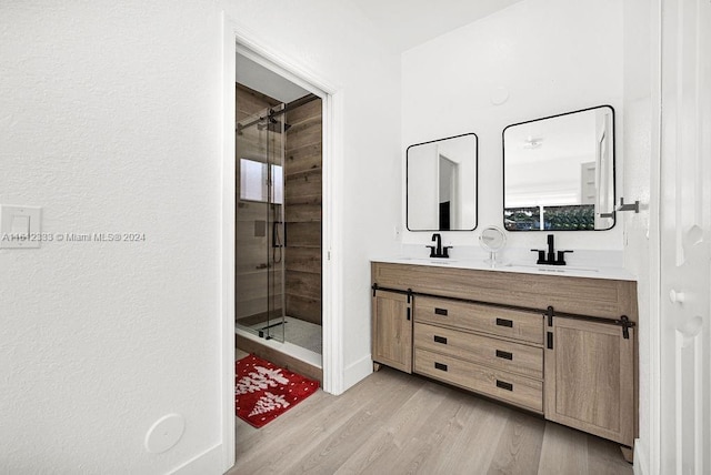 bathroom with hardwood / wood-style floors, vanity, and an enclosed shower