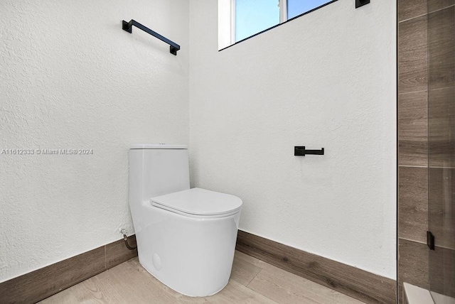 bathroom with hardwood / wood-style flooring and toilet