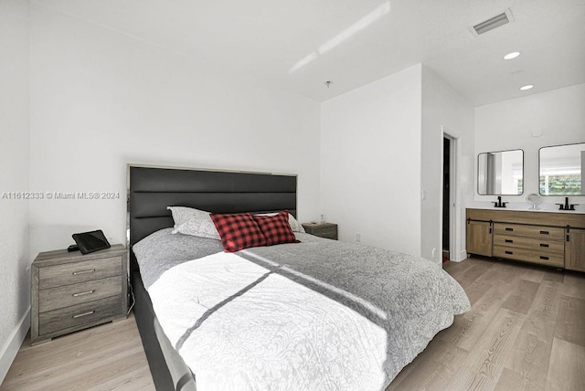 bedroom featuring light hardwood / wood-style flooring and sink