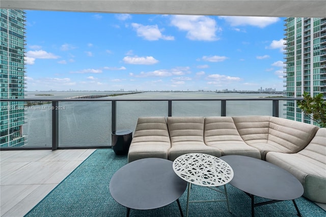 balcony featuring a water view and outdoor lounge area