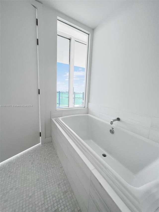 bathroom featuring tile flooring and tiled tub