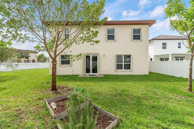 back of property with a yard and french doors