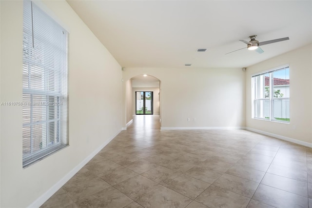 spare room with ceiling fan and light tile patterned floors