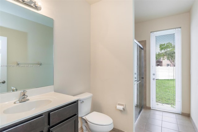 bathroom with tile patterned flooring, vanity, toilet, and a shower with shower door