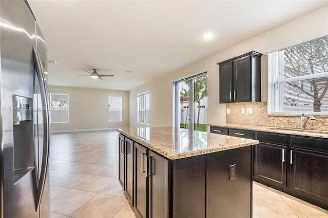 kitchen featuring a center island, backsplash, sink, stainless steel refrigerator with ice dispenser, and ceiling fan