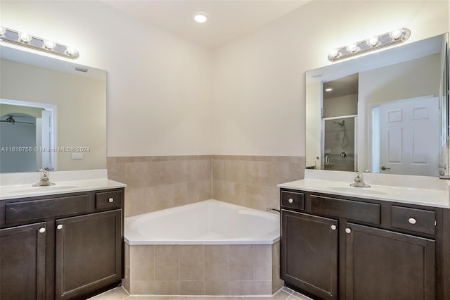 bathroom with tile patterned floors, vanity, and plus walk in shower