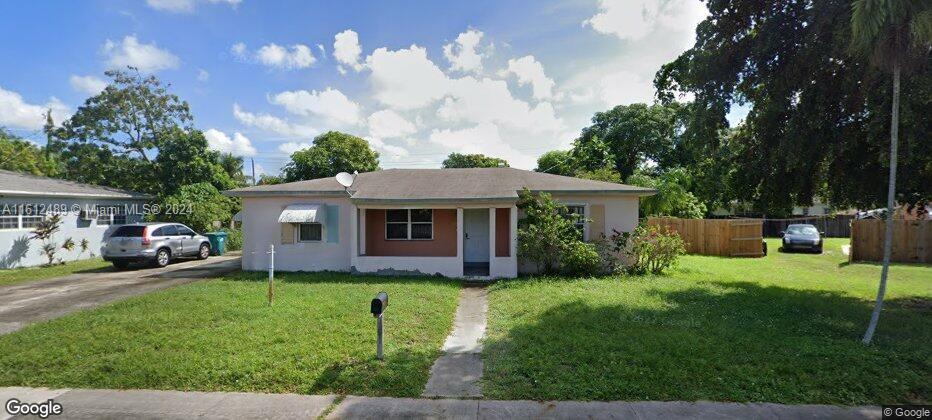 view of front of property featuring stucco siding, fence, and a front yard