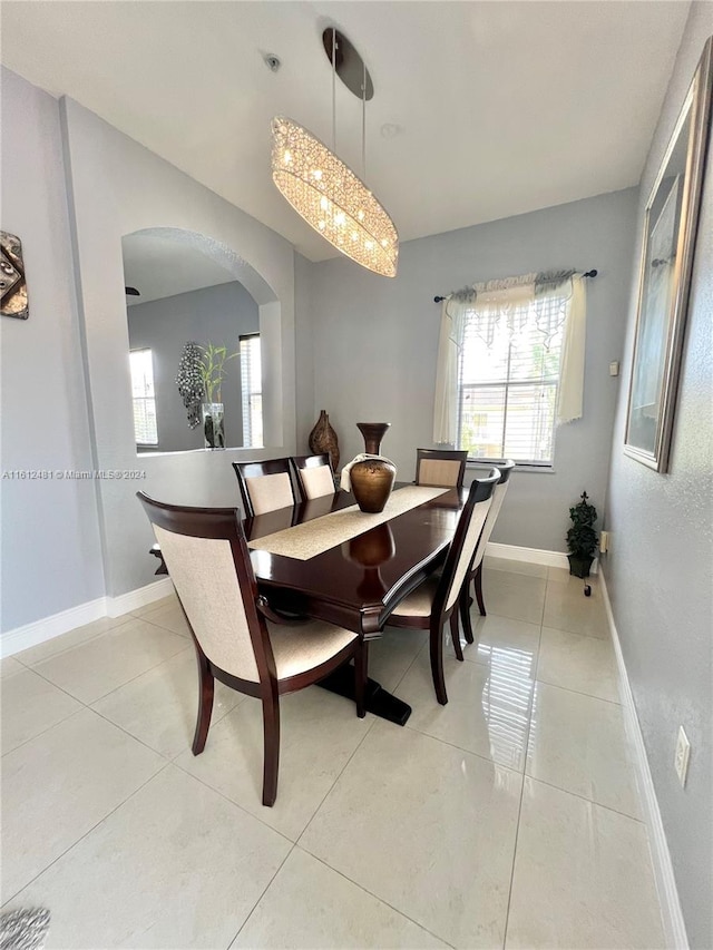 tiled dining area featuring a chandelier