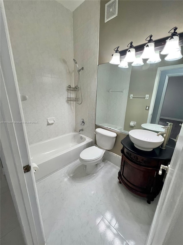 full bathroom with tiled shower / bath combo, toilet, and vanity