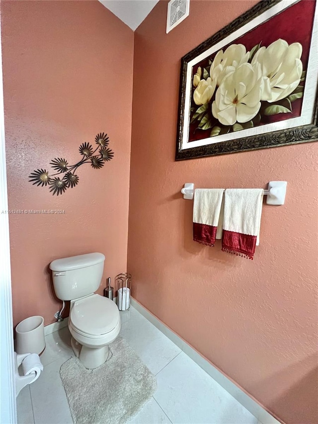 bathroom featuring tile flooring and toilet