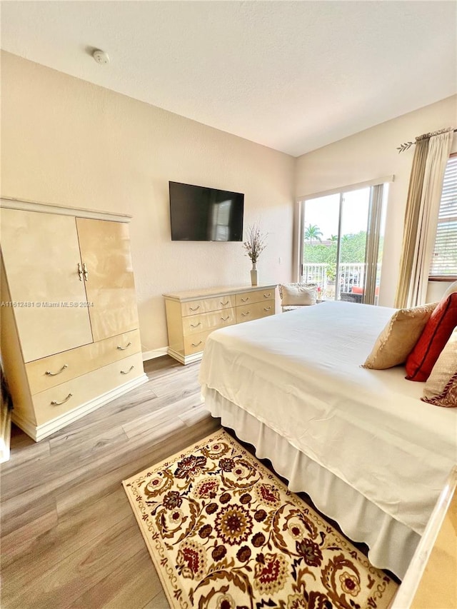 bedroom with light wood-type flooring and access to outside