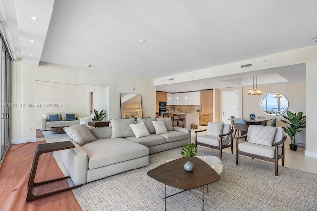 living room with a notable chandelier and light hardwood / wood-style floors