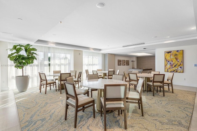 tiled dining room with a raised ceiling