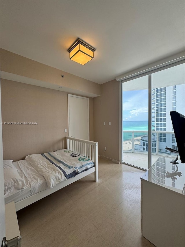bedroom with access to outside, light floors, and expansive windows