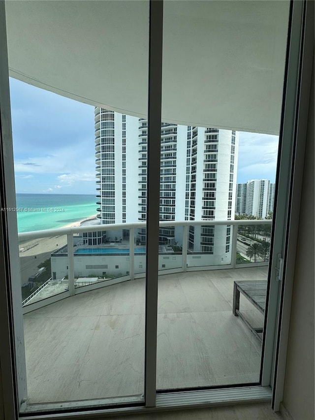 balcony featuring a water view and a view of the beach