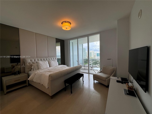 bedroom with access to outside, expansive windows, and light wood-style floors