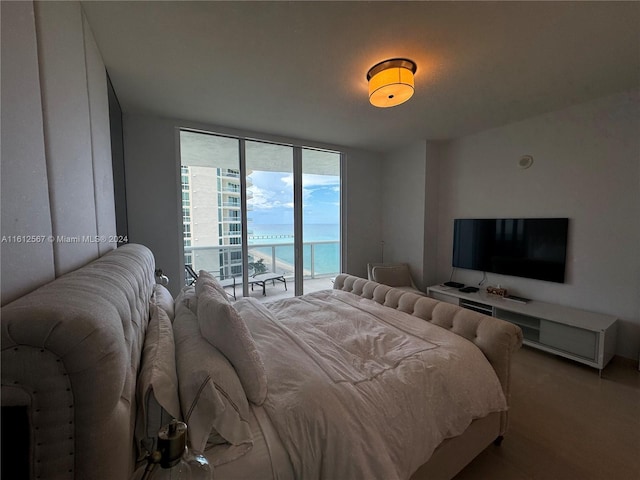 bedroom with a wall of windows and access to exterior