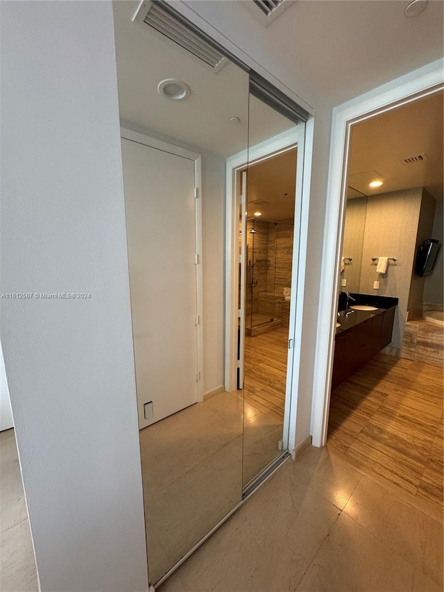 corridor with sink and light tile floors