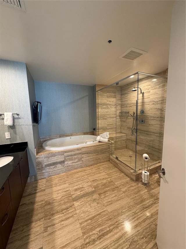 full bathroom with vanity, a stall shower, a garden tub, and visible vents