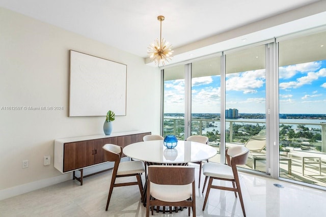 tiled dining space featuring a water view, an inviting chandelier, and a healthy amount of sunlight