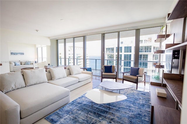 living room with expansive windows, a water view, and wood-type flooring