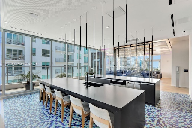 kitchen with a kitchen island, sink, and a wall of windows